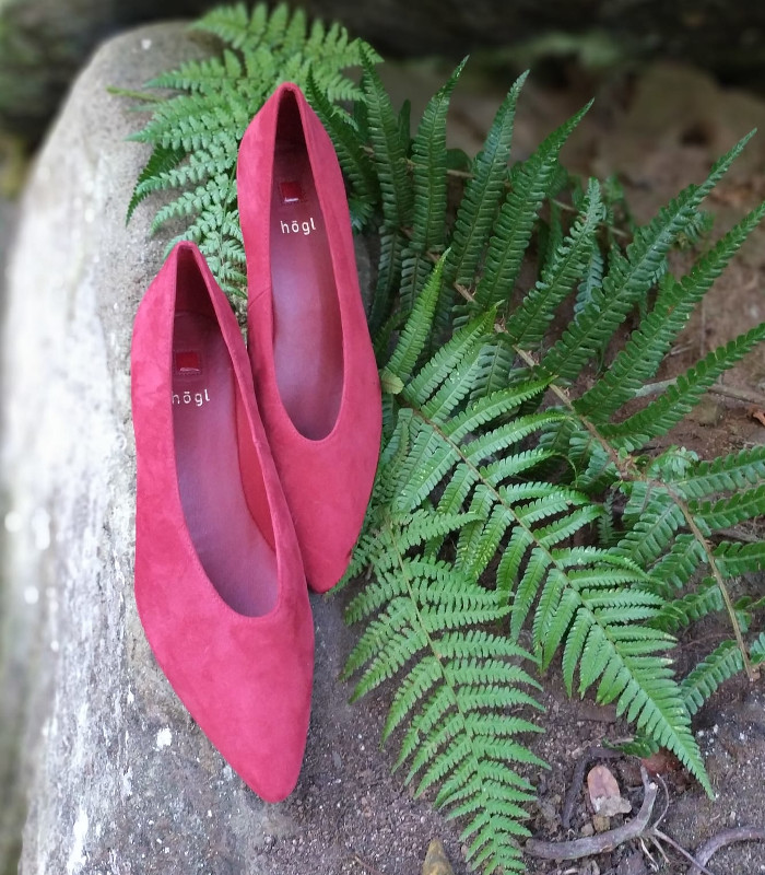 ailarinas Högl de ante rojo con puntera afilada, apoyadas sobre helechos en un entorno de bosque, imagen delicada y sofisticada en clave natural